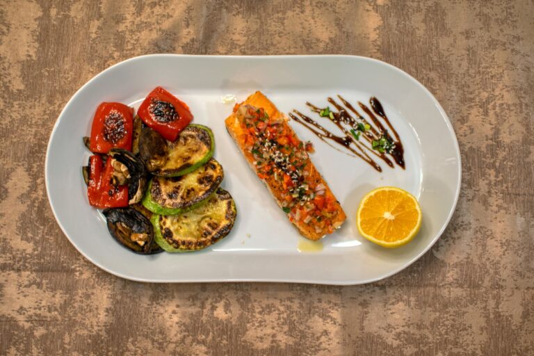 Caramelized honey garlic salmon fillet with sesame seeds on dark plate