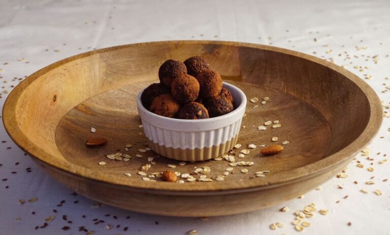 Almond butter energy bites with dark chocolate chips on dark slate surface