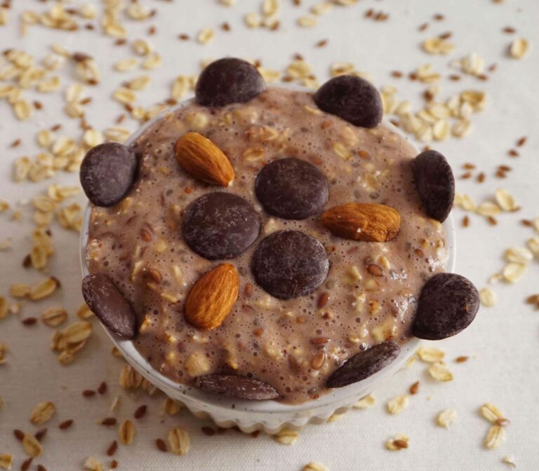 Chocolate protein overnight oats with cacao nibs in glass jar on dark background