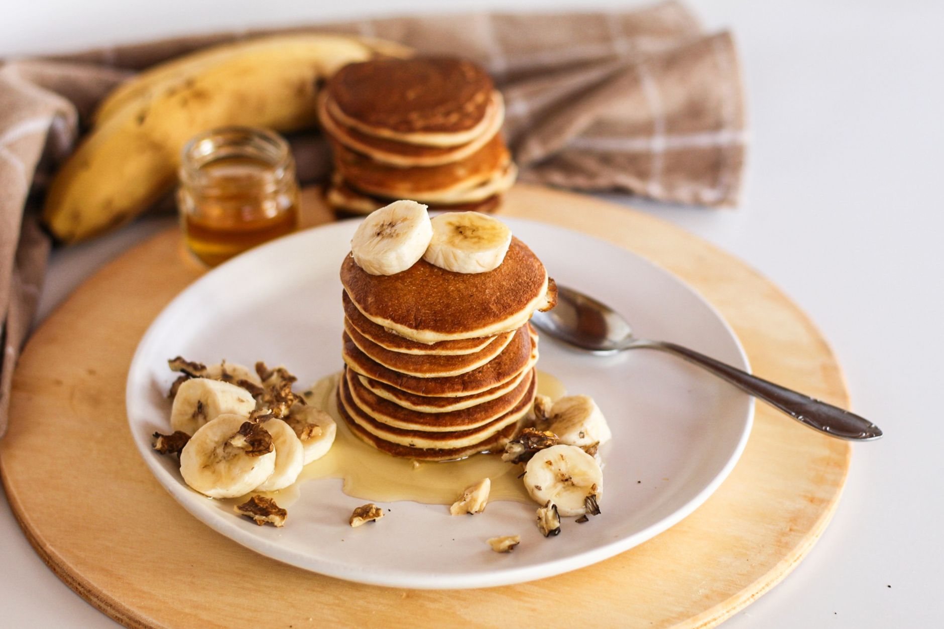 Fluffy cottage cheese banana pancakes with maple syrup on dark plate