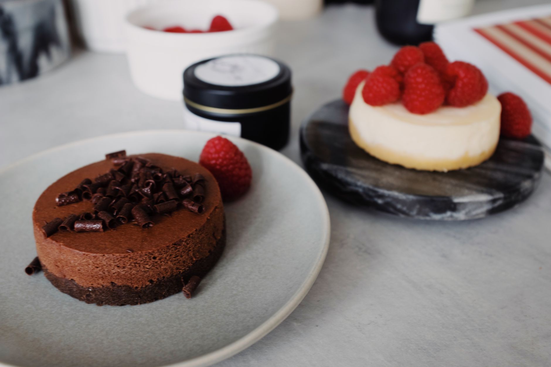 Dark chocolate protein mousse in dark ramekin with raspberries and cacao nibs
