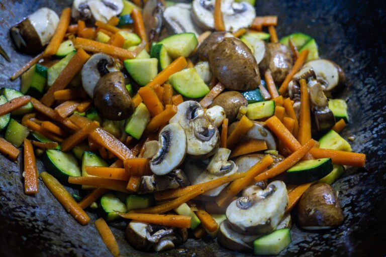 Crispy ginger tofu stir-fry with bok choy and bell peppers in dark wok