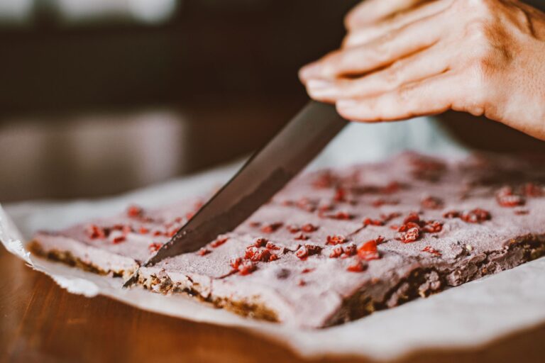 Greek yogurt bark with strawberries and blueberries broken into pieces on dark parchment