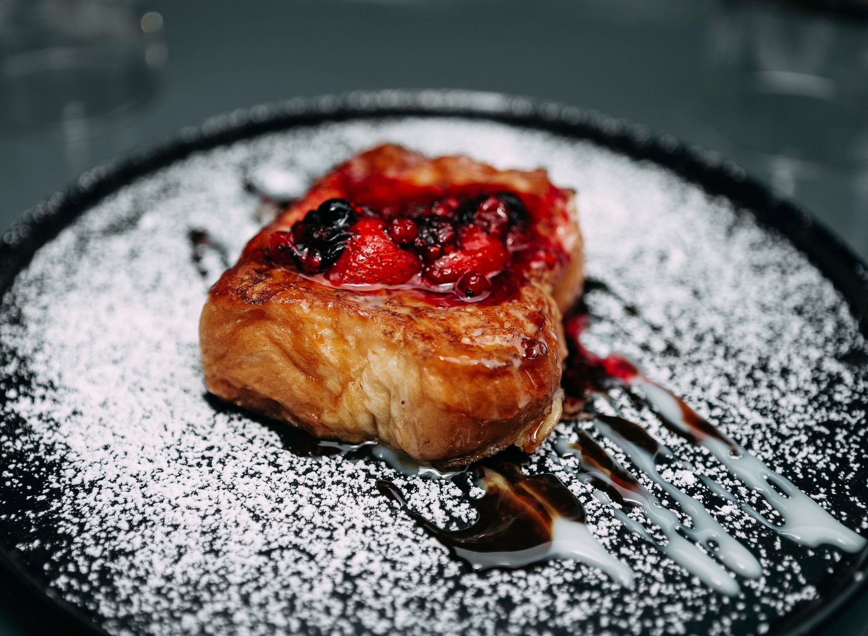 High-protein French toast stack with berries on dark plate