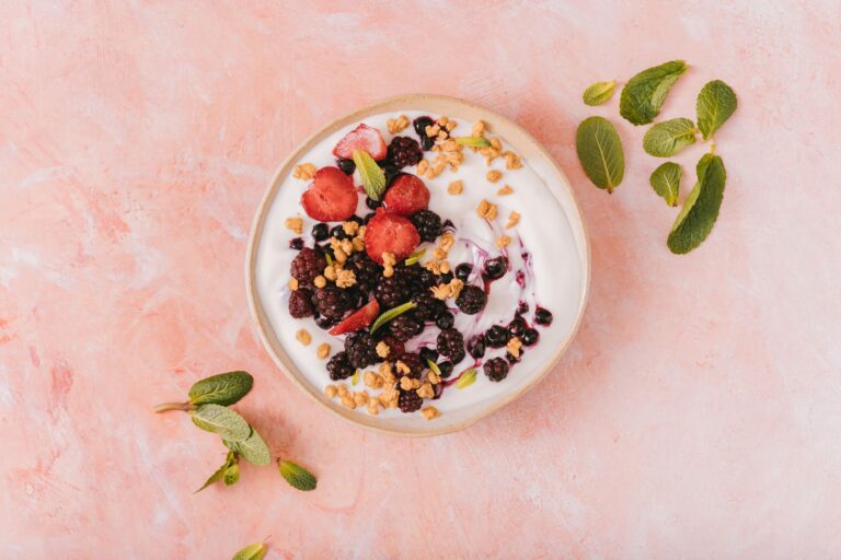 High-protein smoothie bowl with berries, granola and chia seeds in dark ceramic bowl