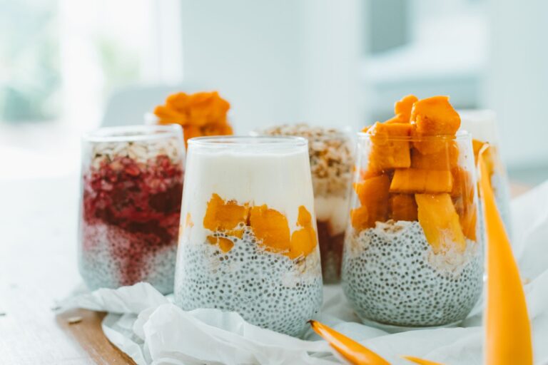 Mango coconut chia pudding in glass jar with fresh mango and coconut flakes