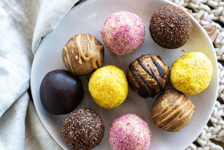 No-bake protein energy balls rolled in coconut on dark slate surface