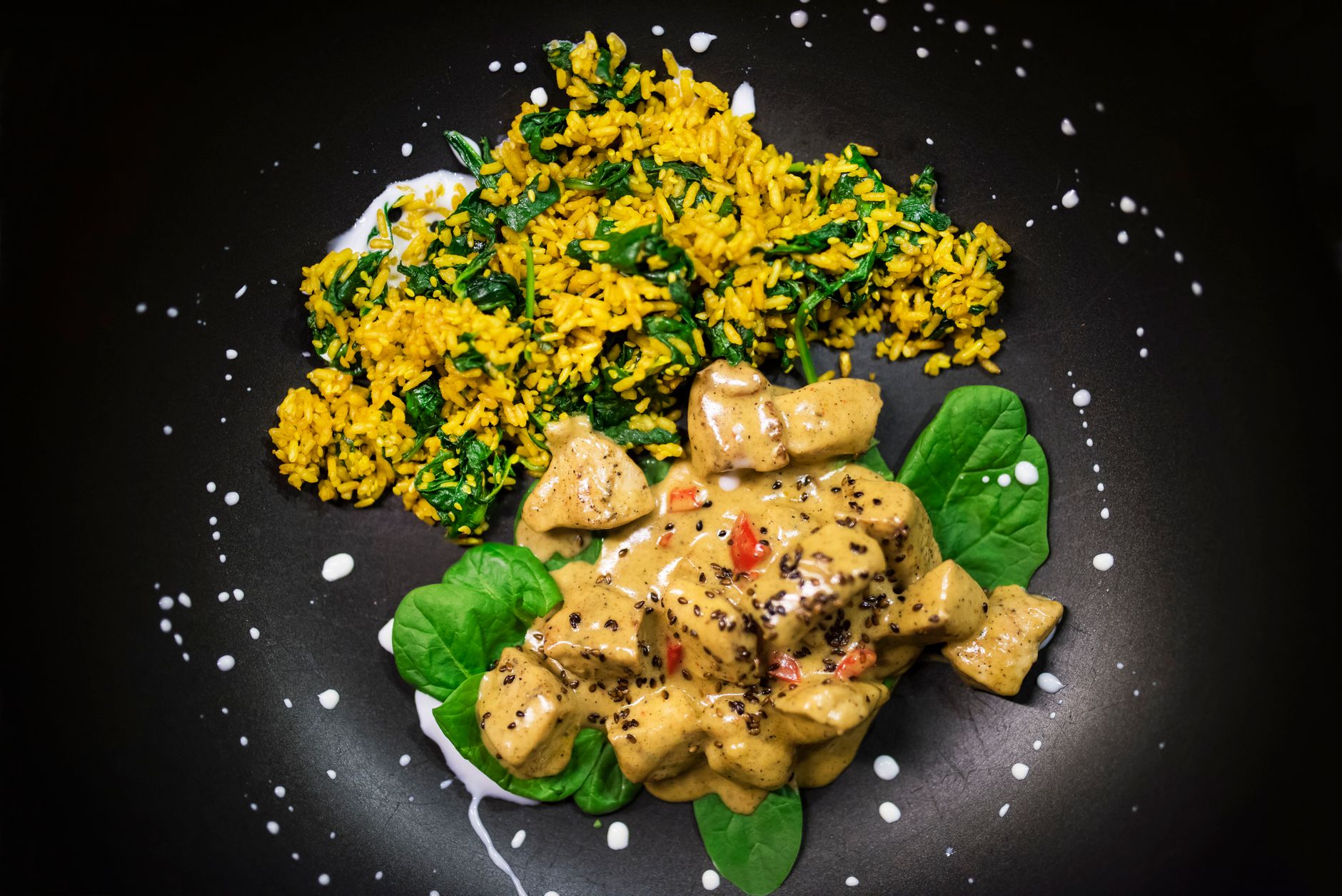 Creamy Tuscan chicken with sun-dried tomatoes and spinach in dark cast iron skillet
