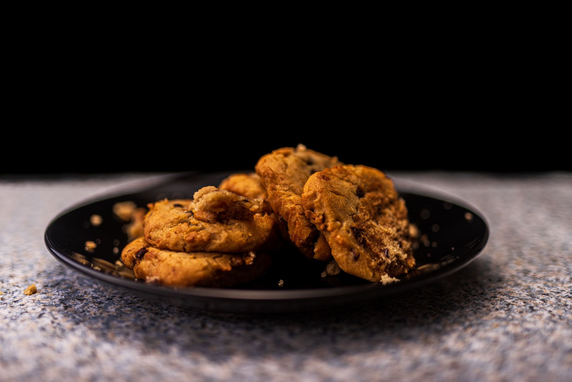 Soft peanut butter protein cookies with chocolate chips on dark slate