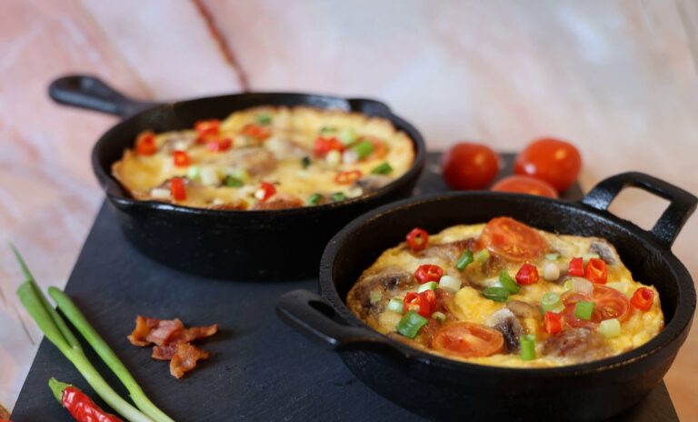 Folded egg white omelette with spinach and mushrooms in dark cast iron pan